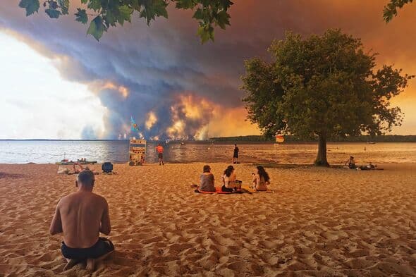 Jaw-dropping moment tourists relax on beach as wildfires rage near Bordeaux