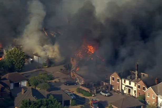 Massive wildfire burns six homes and injures two as 100 firefighters tackle blaze