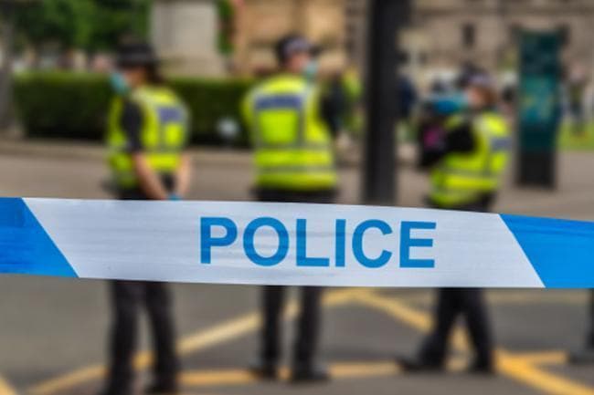 Police seal off busy road after injured man discovered on street
