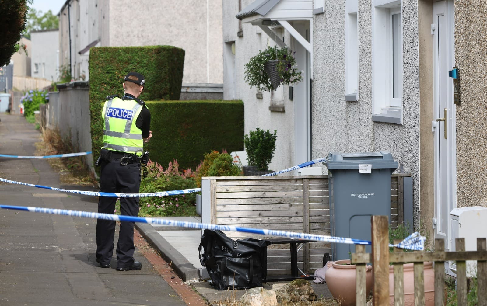 Police stand guard on East Kilbride street amid probe into death of woman