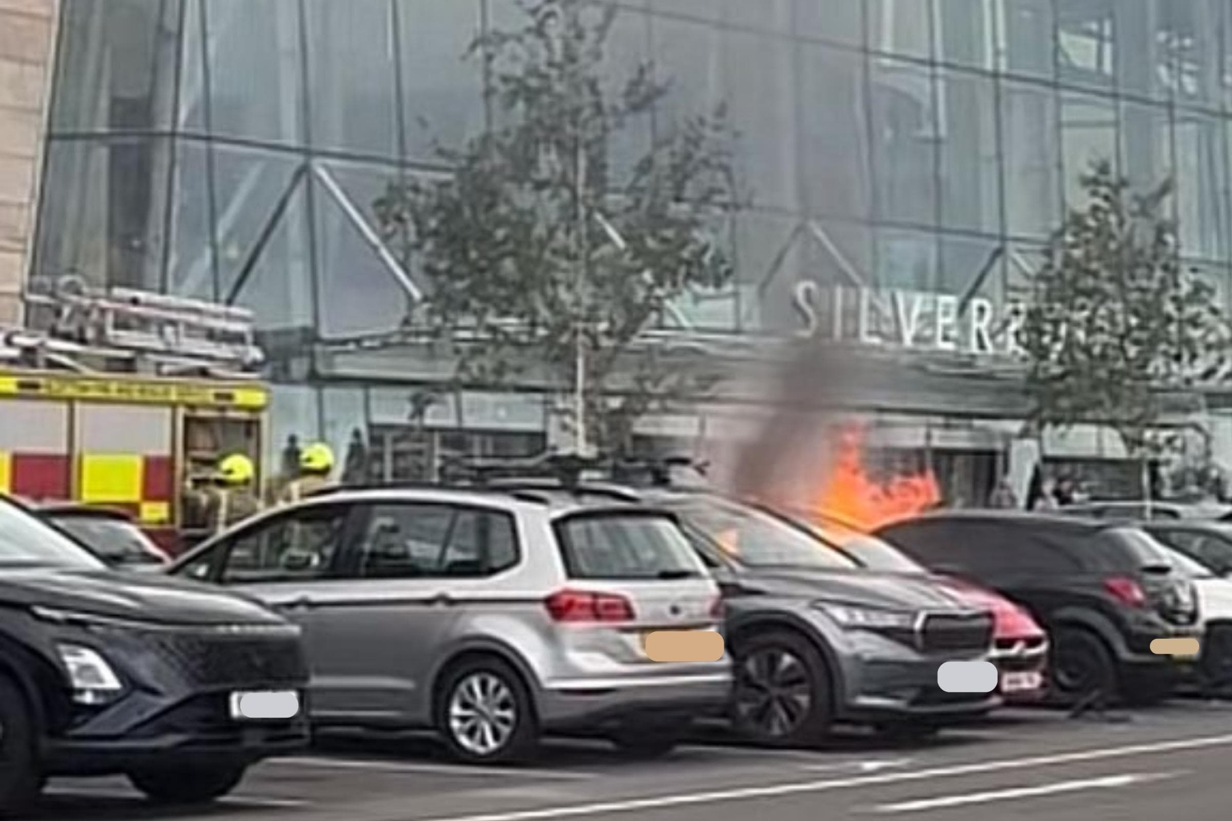Smoke billows across popular shopping centre after fire breaks out in car park
