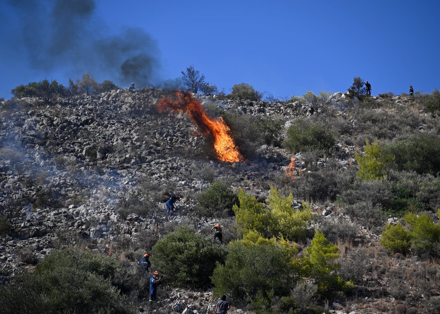 Fire crews battle blazes in Belgium and Greece as two die on island near Athens